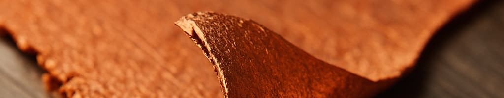 Metal parts with peeling and blistered plating, annotated to show adhesion failure at the substrate interface